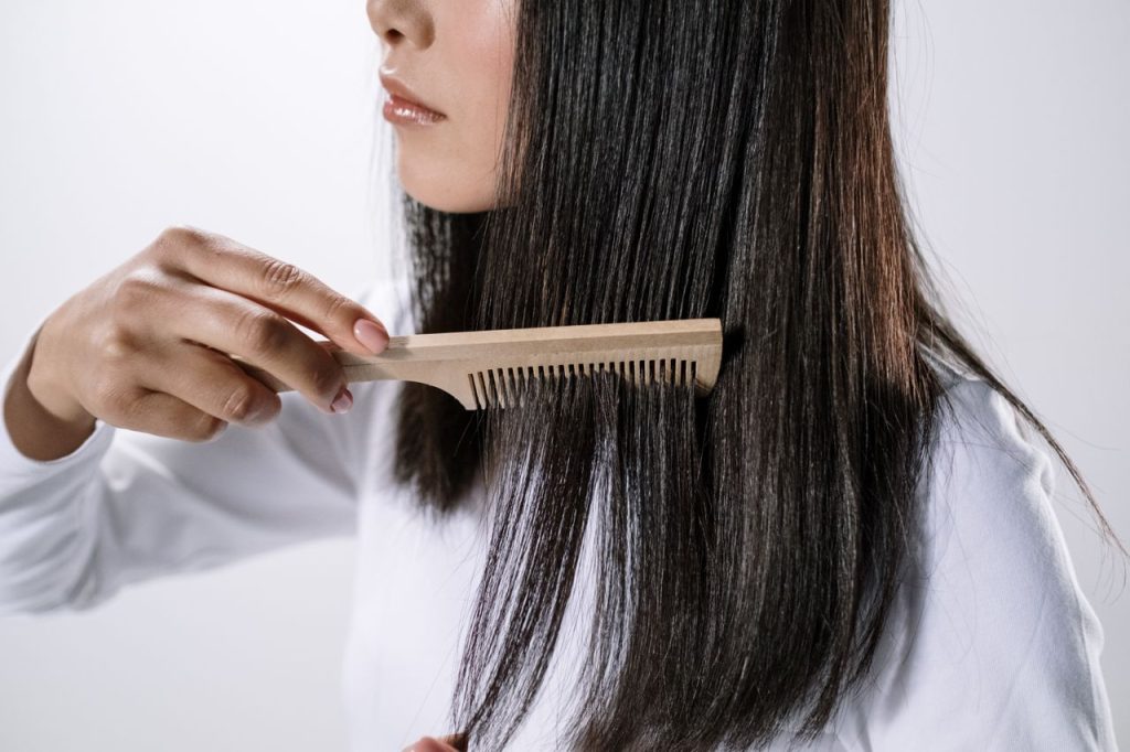 Woman caring for healthy hair as part of a comprehensive hair and scalp health routine