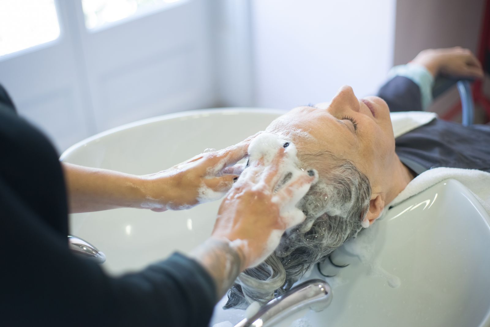 Woman gently washing and massaging her scalp during a hair care routine