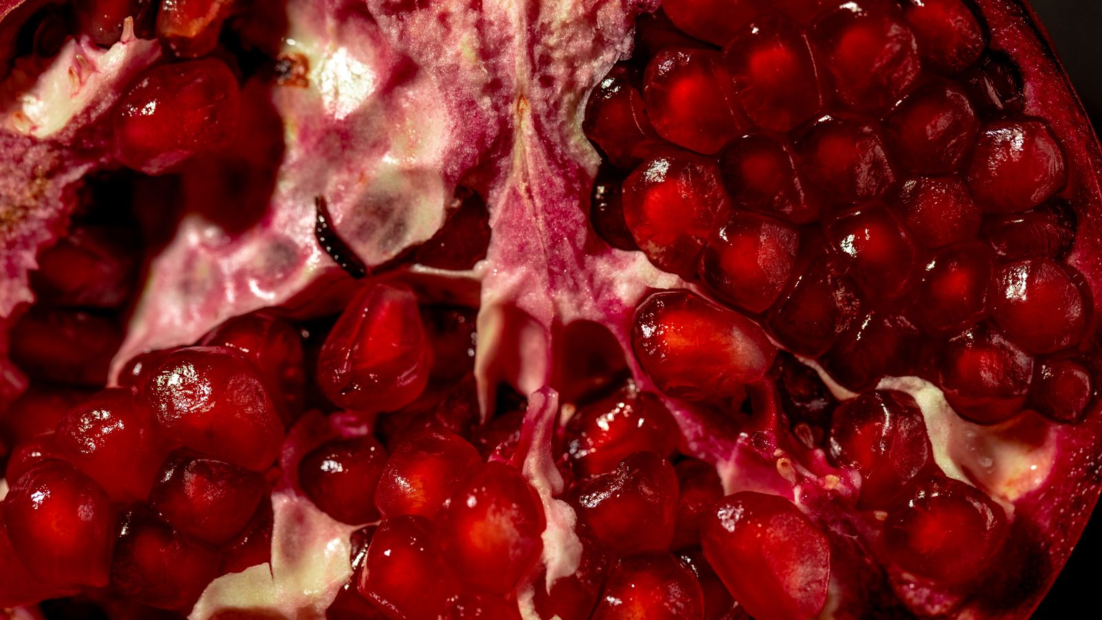 Close-up of vibrant red pomegranate seeds showing their color and texture.