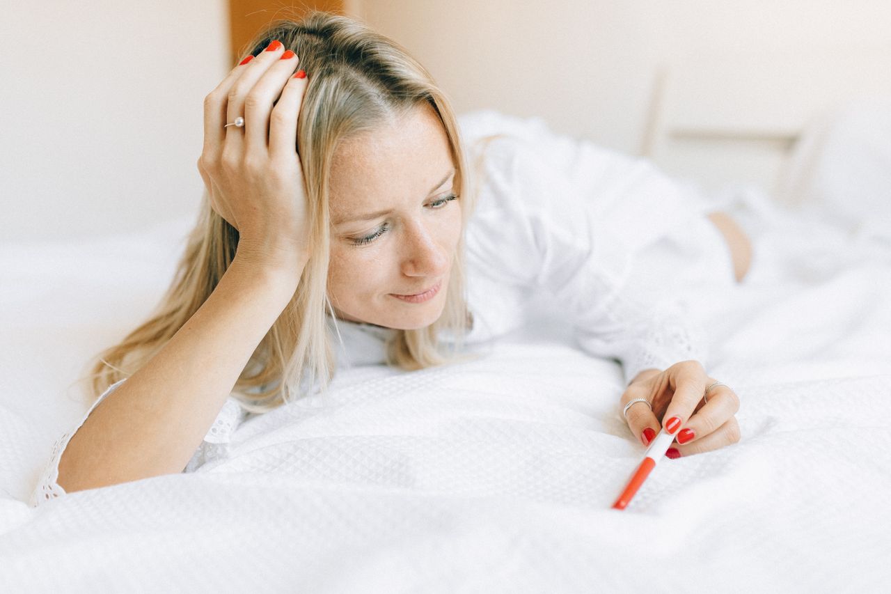 Woman considering a pregnancy test after a late menstrual period