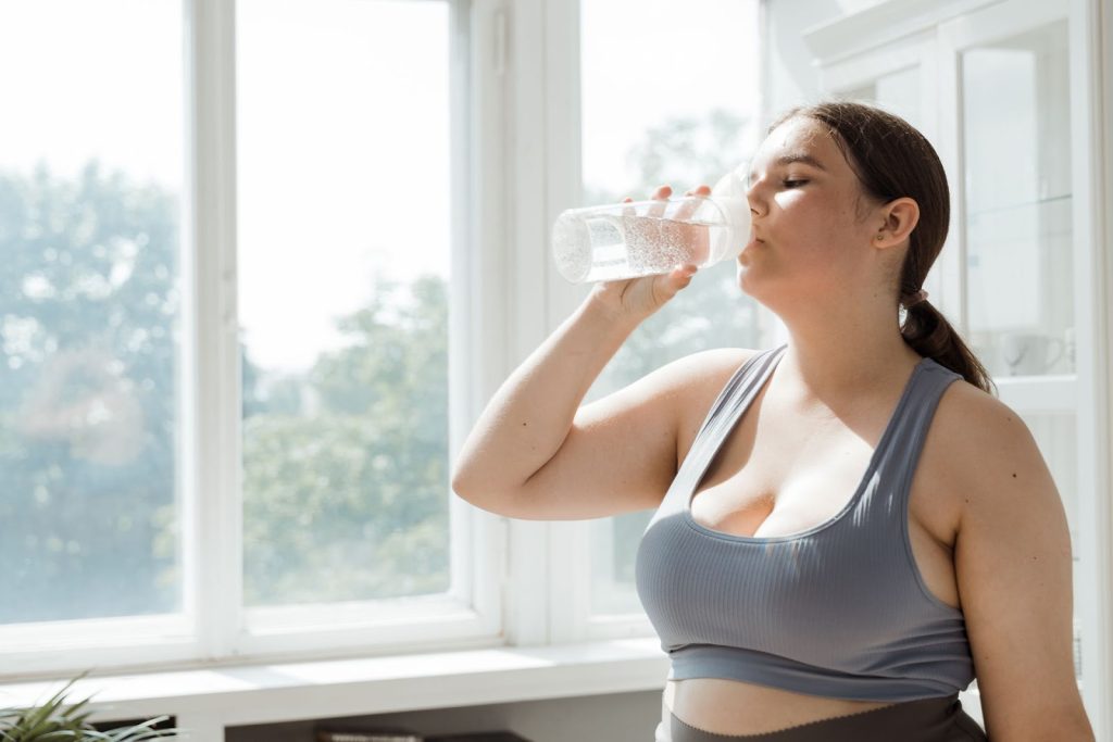 Woman drinking water to support hydration during daily activities