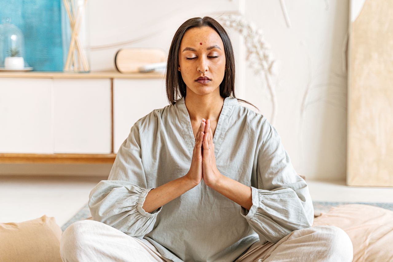 A woman sitting quietly with her eyes closed during a mindfulness practice.