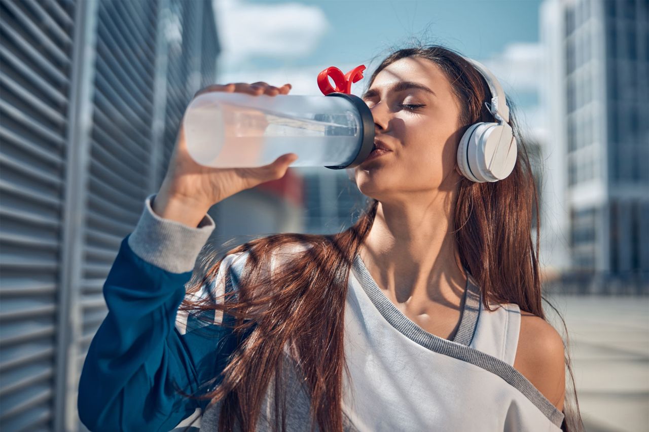 Woman drinking water after physical activity