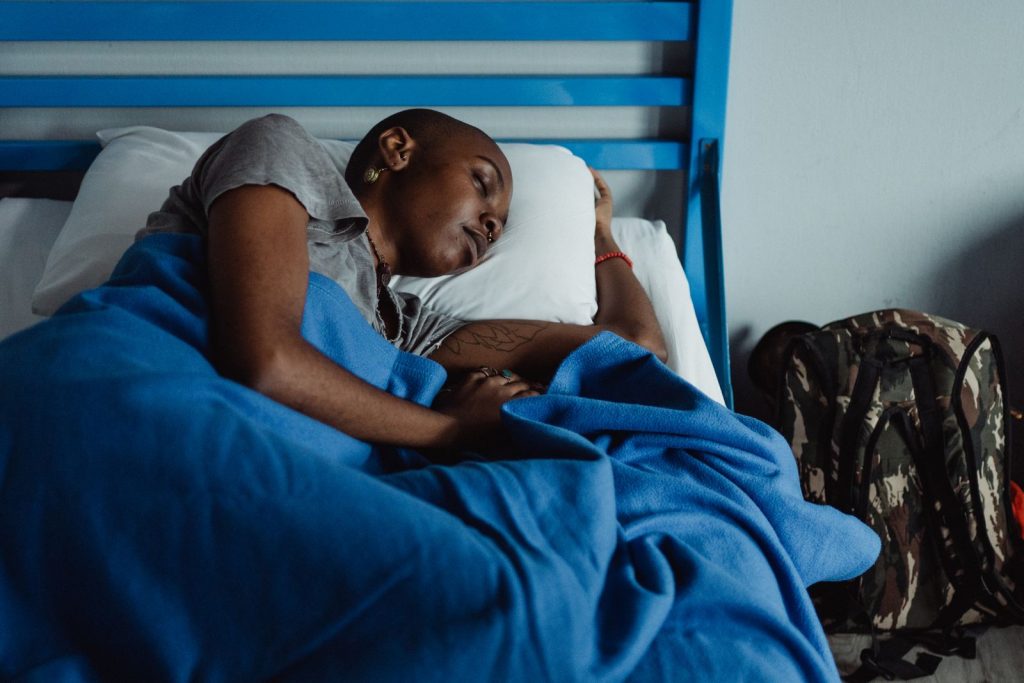 Woman sleeping comfortably in bed, illustrating the importance of quality sleep for metabolic health.